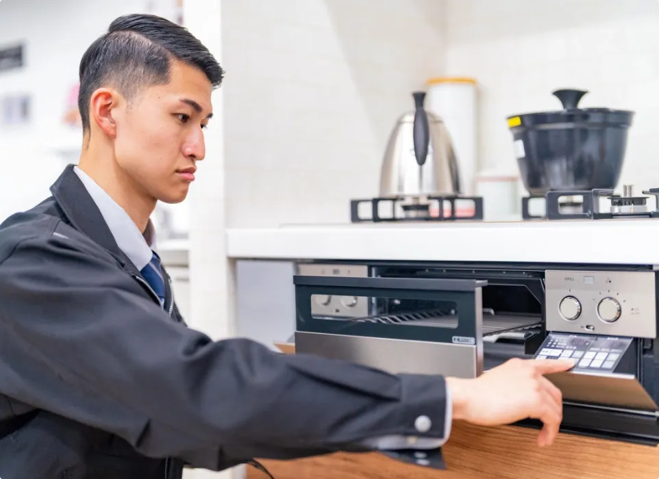 ガスコンロのスイッチを点検しているスタッフの様子