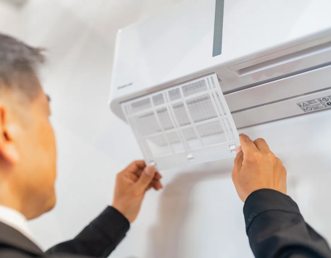 エアコンのフィルターを取り外しているスタッフの様子