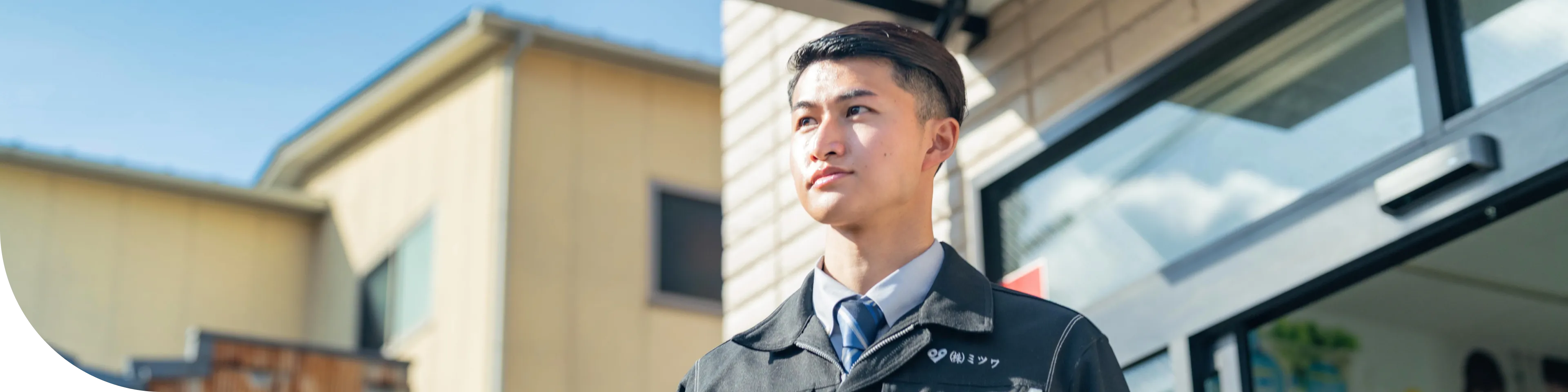 男性スタッフが事務所を背に前を向いている写真