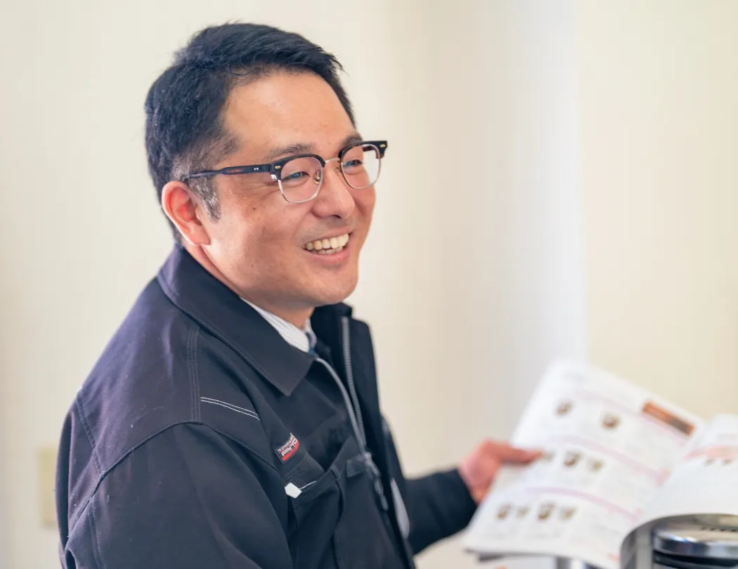 カタログを手に持って話をしているスタッフの様子